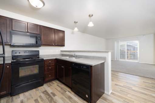 A kitchen with dark wood cabinets and a black oven.