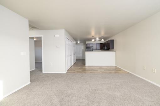 A large empty room with a carpeted floor and white walls.