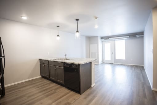 Spacious, combined kitchen and living room with breakfast bar seating.