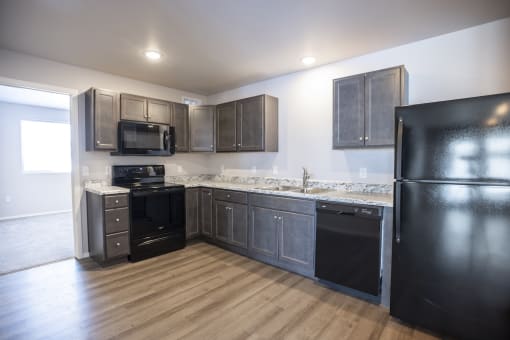 Modern open-concept kitchen and living area with black appliances.