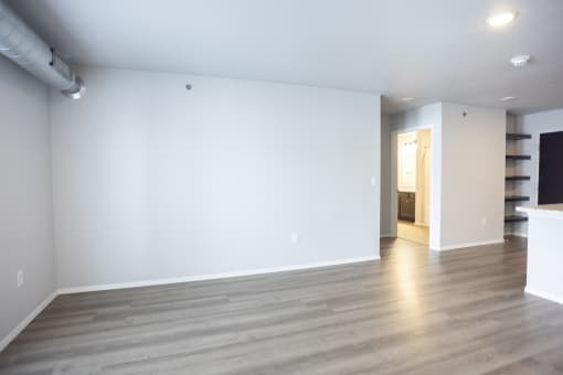 Empty living room with large, bright windows.