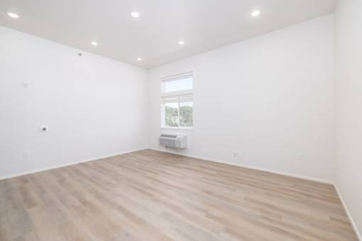 A room with wooden flooring and a window.