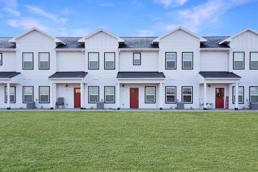 A row of white houses with red doors.