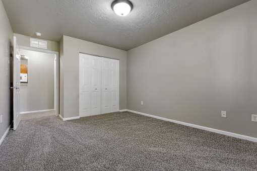 A room with a carpeted floor and a white door.