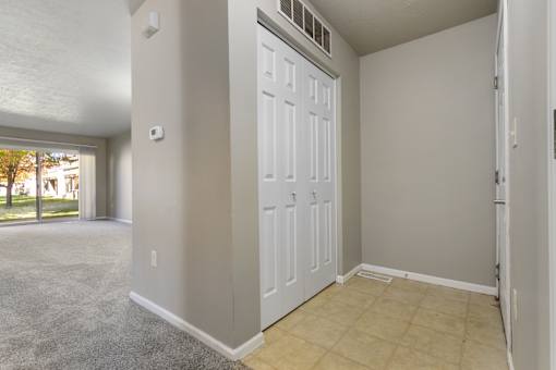 A white door is in a room with a carpeted floor.