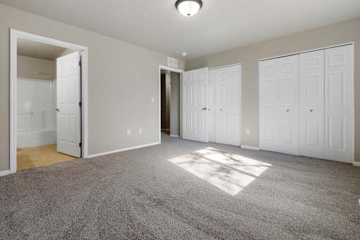 A room with white doors and a carpeted floor.