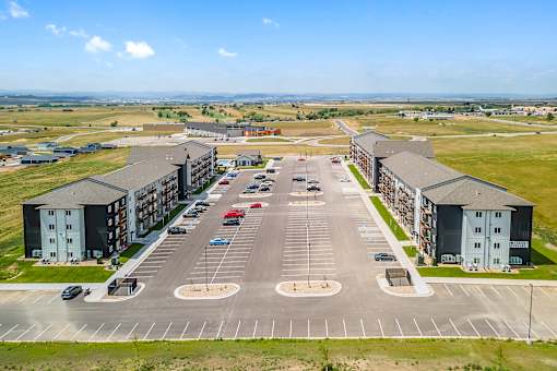 A parking lot with cars and apartment buildings in the background.