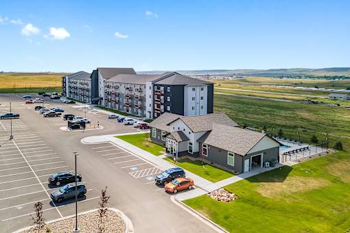 A parking lot with cars and a building in the background.