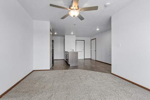 A room with a ceiling fan and a carpeted floor.