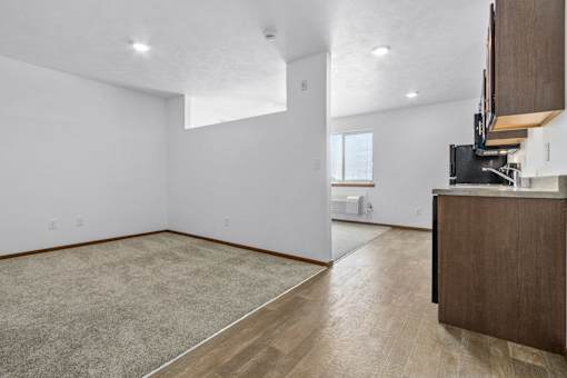 A room with a carpeted floor and a wooden cabinet.