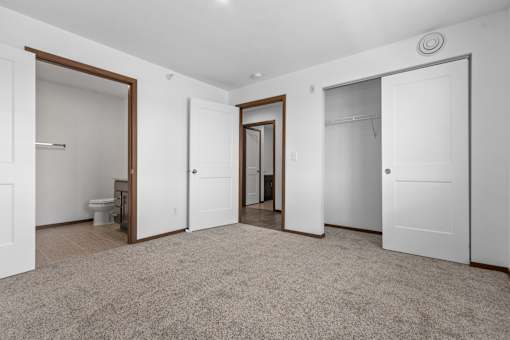 A spacious room with carpeted floor and white walls.