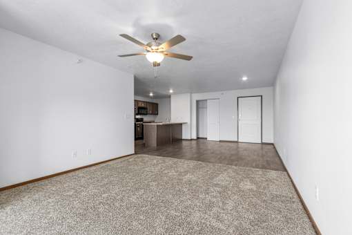 A room with a ceiling fan and a carpeted floor.
