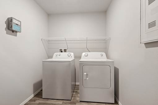 Two white washing machines in a small laundry room.
