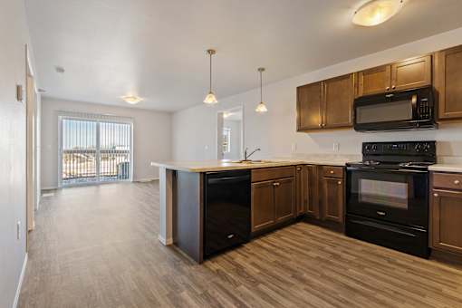 A kitchen with black appliances and wooden cabinets.