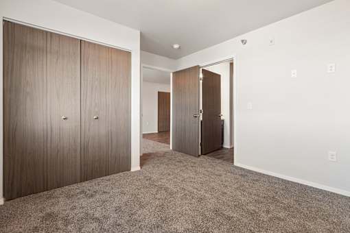 A room with a carpeted floor and two wooden doors.
