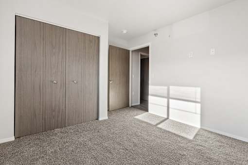 A room with a carpeted floor and a wooden door.