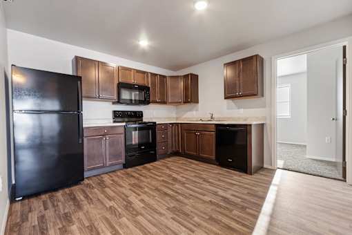 A kitchen with wooden floors and brown cabinets.