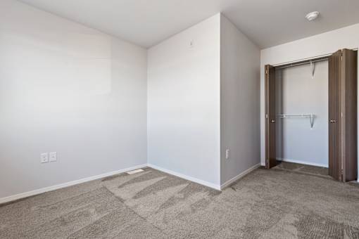 A room with a carpeted floor and a door.