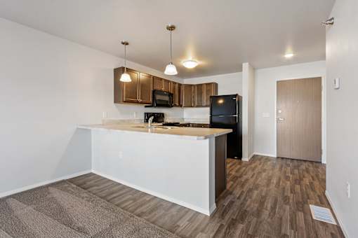 A kitchen with a white counter and wooden cabinets.
