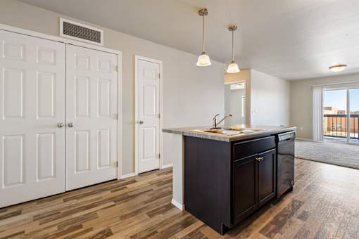 A kitchen with a black island and white cabinets.