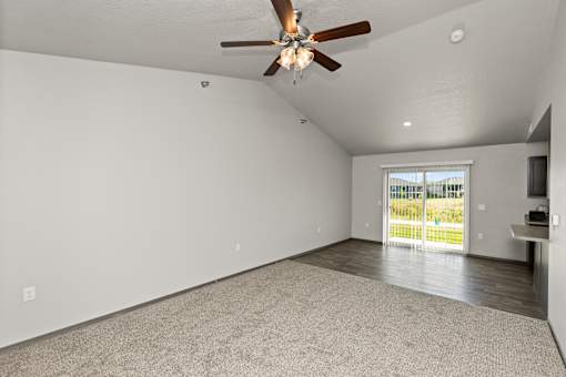 A room with a ceiling fan and a carpeted floor.