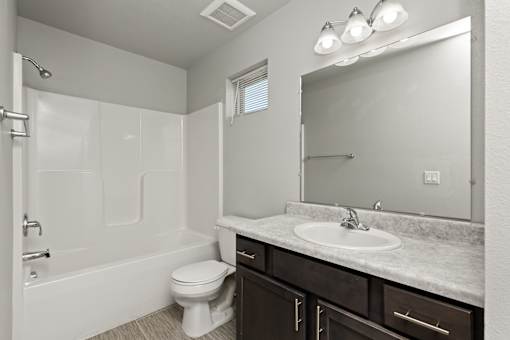 A white bathroom with a toilet, sink, and shower.