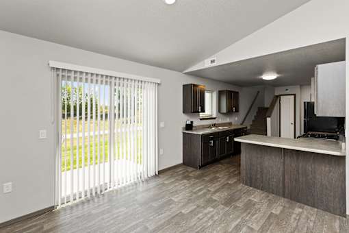A modern kitchen with a sliding glass door leading to a backyard.