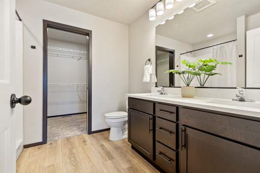 A bathroom with a toilet, sink, and mirror.