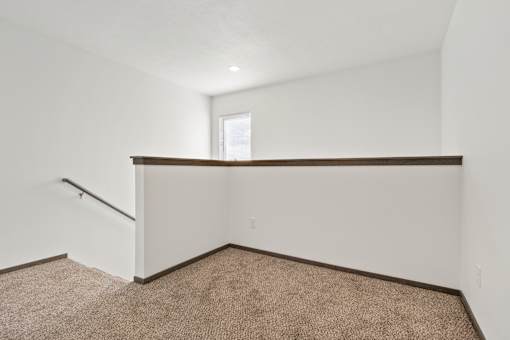 A room with a carpeted floor and a window.