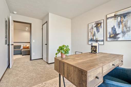 A room with a wooden table and two paintings on the wall.