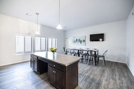 A kitchen with a table and chairs in front of a window.