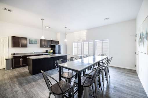 A kitchen with a table and chairs in front of it.