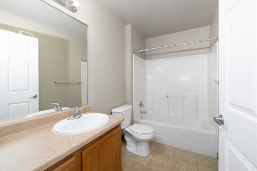 A white toilet sits next to a sink in a bathroom.