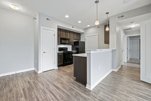 a renovated kitchen and living room with white walls and wood flooring