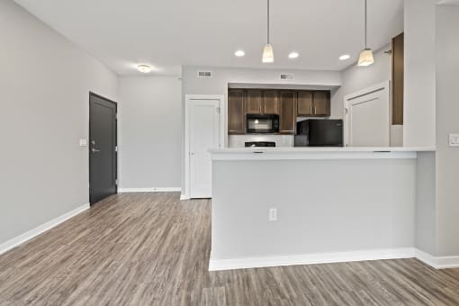 an kitchen and living room with a counter top and a refrigerator and a microwave