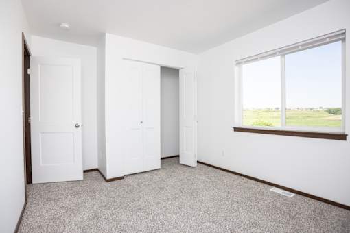 an empty room with two doors and a window
