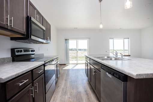 a large kitchen with stainless steel appliances and marble counter tops
