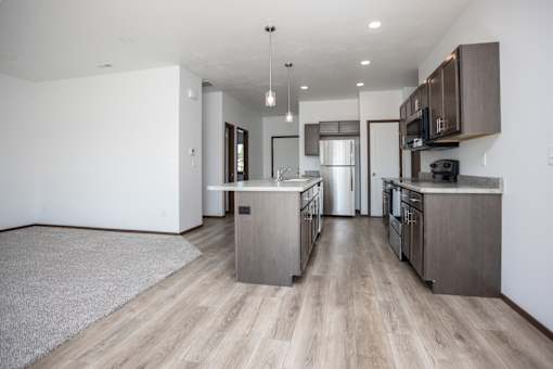 a kitchen and living room with wooden floors and stainless steel appliances