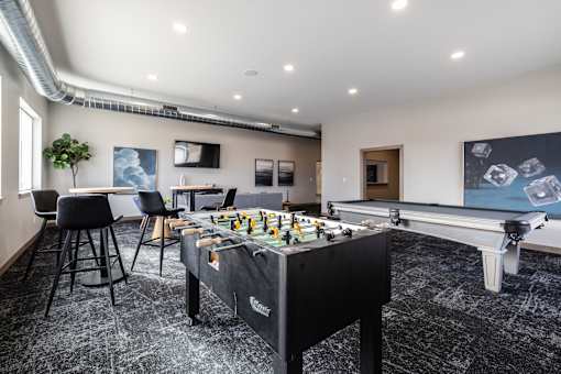 A foosball table is in the middle of a room with a black and white floor.