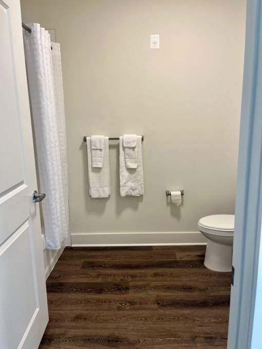 a small bathroom with two towels hanging on the wall and a toilet