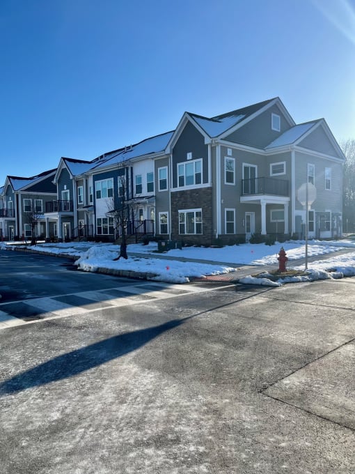 an apartment building with a red fire hydrant in the snow