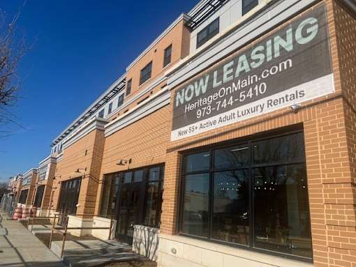 A building with a sign that says "NOW LEASING" on it.