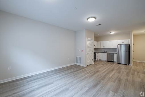A kitchen with white cabinets and a stainless steel refrigerator.