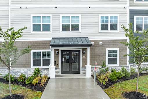 A building with a grey facade and a black awning.