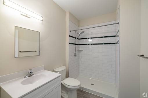 A white bathroom with a sink, toilet, and shower.