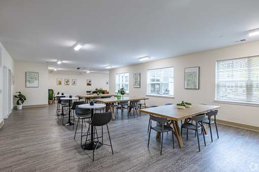 A large room with tables and chairs is empty.