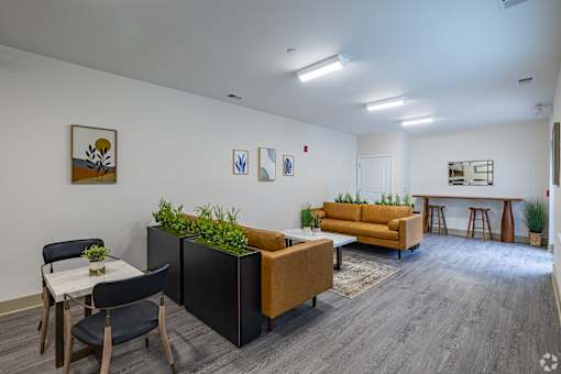 A modern living room with a dining table and chairs, a couch, and a bar area.
