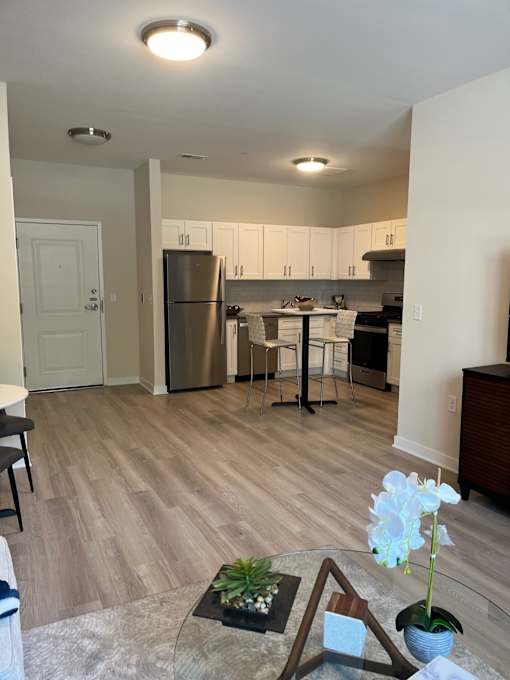 A kitchen with a refrigerator, table, and chairs.