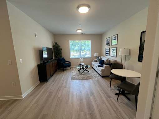 A living room with a couch, a coffee table, and a television.