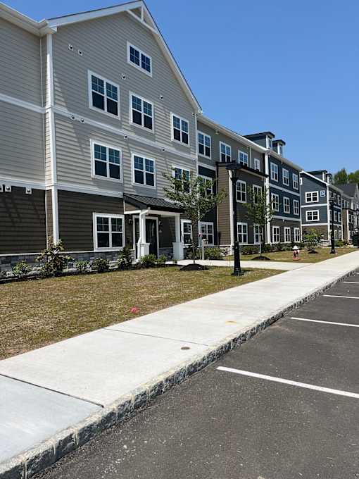 Apartment building with a parking lot in front.